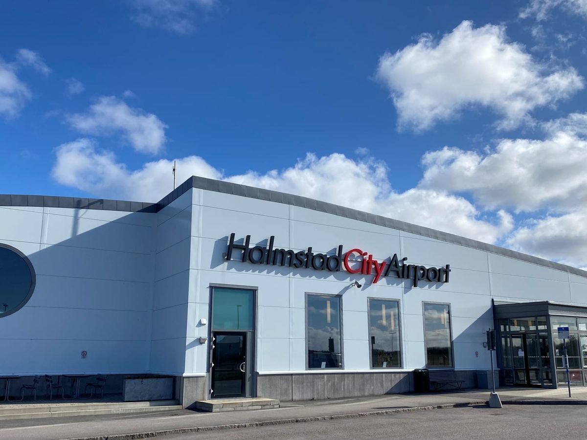 Terminalbyggnaden på Halmstad City Airport med skylten Halmstad City Airport mot blå himmel