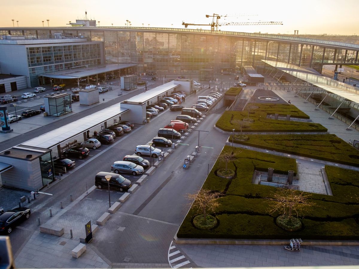 Terminal 3 på Köpenhamns flygplats Kastrup sedd ovanifrån i kvällsljus, med vägen fram till terminalen