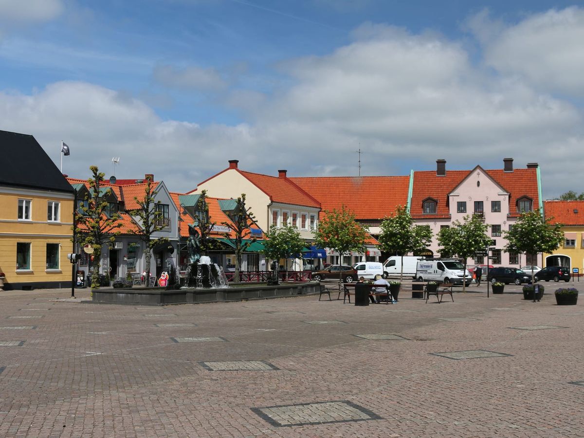 Stortorget i Laholm med Lagafontänen och gamla hus med röda tegeltak en solig dag