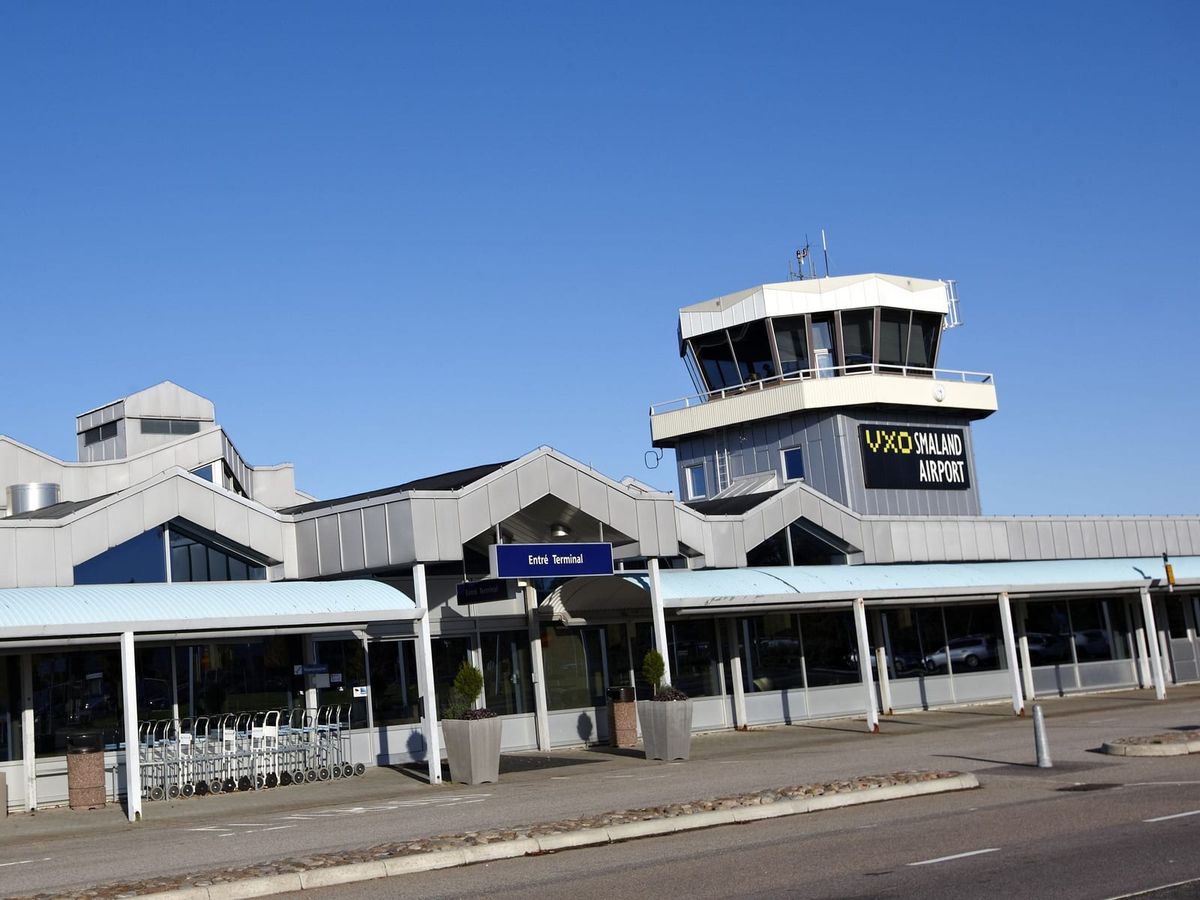 Entrén till terminalen på Växjö Småland Airport med kontrolltornet och skylten VXO Småland Airport